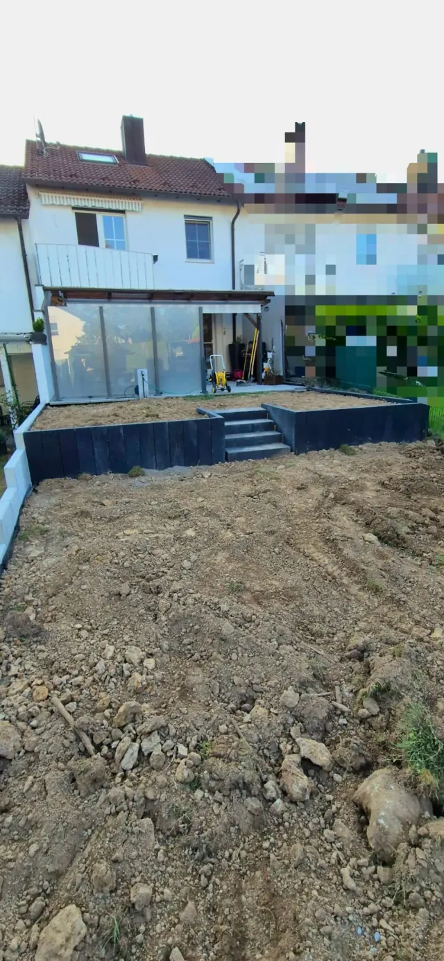 Terrassierter Hang mit Palisaden und Treppe während der Erdarbeiten