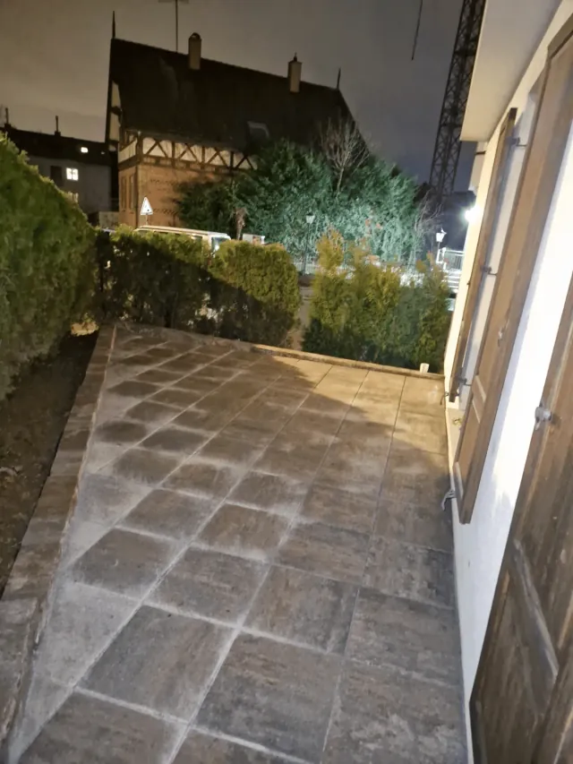 Terrasse mit Natursteinplatten entlang der Hauswand