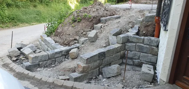 Natursteinmauer und Treppe am Hang im Bau