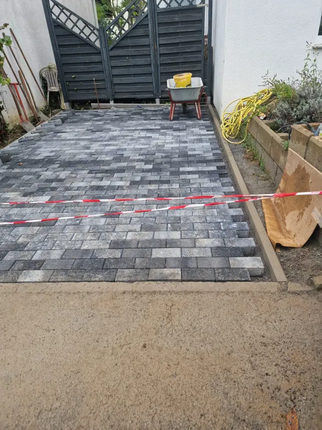Stellplatz neben dem Haus mit dunklem Betonpflaster
